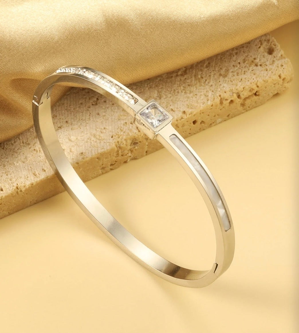 Aurelia Mother-of-Pearl Bangle – silver version styled on stone surface