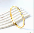 Aurelia Mother-of-Pearl Bangle – gold version styled on white ridged surface