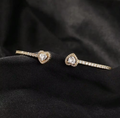 Amour Heart Zircon Open Bangle – Gold detail shot on black velvet