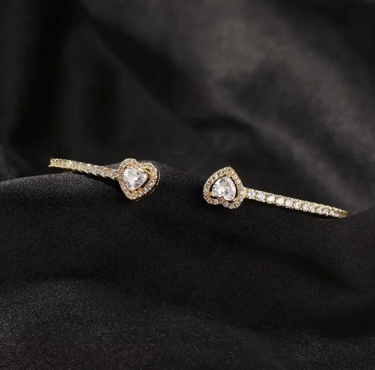 Amour Heart Zircon Open Bangle – Gold detail shot on black velvet
